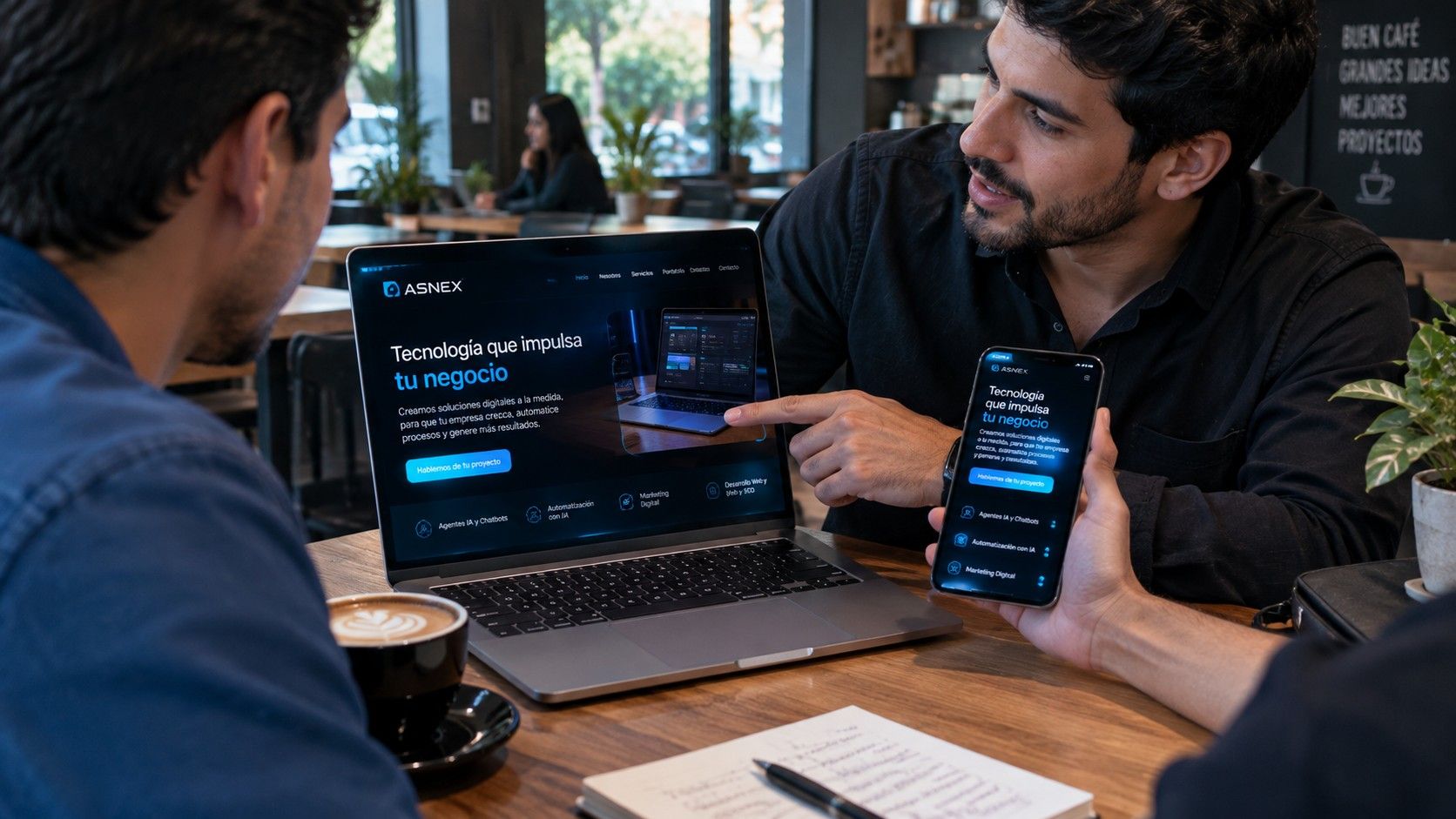 Emprendedor muestra a un cliente su nueva página web en el computador y en el celular